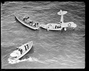 People being rescued by boats from United States Army Air Service airplane wreck