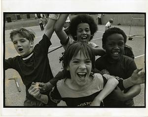 Four boys clown for camera on a playground