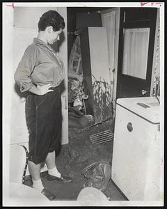Pretty Mimi Horwitz looks at mud oozing into back porch and kitchen at her home on Mason Terrace, Brookline. This followed landslide of mud and rocks on hill in back yard.