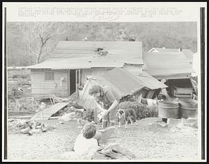 W. VA: A mother washes child's diapers in pail in front of what remains of her home 2/28 as young child looks on. Flood waters ripping down this narrow valley 2/26 brought death to at least 66 persons and left about 4,000 homeless.