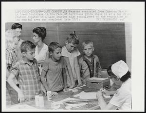 Lake Charles, LA: Persons evacuated from Cameron Parish in lower Louisiana in the face of hurricane Hilda check in at a Red Cross station located in a Lake Charles high school. Most of the evacuation of low coastal area was completed late 10/1.