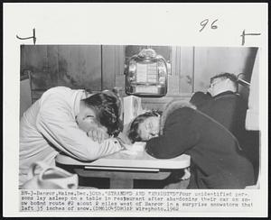 Bangor, Maine. "Stranded and Exhausted" Four unidentified persons lay asleep on a table in restaurant after abandoning their car on snow bound route #2 about 2 miles west of Bangor in a surprise snowstorm that left 35 inches of snow.