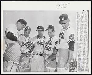 Bradenton, Fla. – There’s A Hitch To This One – Slightly befuddled Milwaukee Brave players get instructions from coach Connie Ryan as they hook up new external sliding pads at the club’s training camp today. From left are: Clarence (Buck) Riddle and Joe Koppe, rookie infielders; Ryan, Andy Pafko, veteran outfielder, and first base regular Joe Adcock, who looks like he’s really stymied by the whole thing. Pads are used as extra protection in sliding drills although most players already wear protective covering for sliding underneath their uniforms.