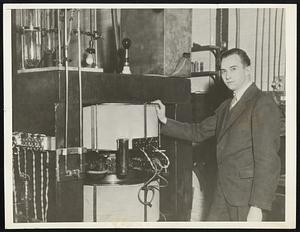 Scientist With "Atom Buster". Dr. Stanley Livingston is shown beside the $5,000 cyclotron, which is capable of producing artificial radium as well as breaking down the structure of atomic nuclei, at Cornell University. The cyclotron develops 2,500,000 volt rays.