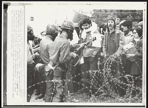 Face Off--Military police hold off antiwar demonstrators from the Ft. Dix Army post today. The demonstrators shoved leaflets on the soldiers' weapons. Later several hundred tore down the barbed wire fence and invaded the reservation. They were driven back by the military police and by state police who sprayed tear gas.