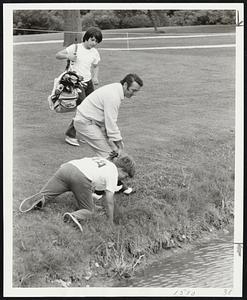 Bruins Team Checked -- Eddie Johnston, Bruins goalie, looks for golf ball he hit into pond at left as two caddies assist. Ar right, Ed walks away (second from right) while partner Johnny McKenzie, right, lingers.