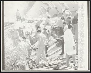 Rescue workers carry a stretcher with an injured patient at the Veterans Administration Hospital in the north San Fernando Valley. At least eleven persons at the hospital were killed when the three-story building collapsed during a rumbling earthquake which hit the Southern California area early 2/9.