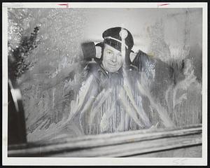 Cold Outside -- Milkman Chester Fitzgerald of 94 Jacques street, Somerville, pauses in his rounds to peer through frosted window and try to keep his ears warm for a minute as cold spell continued.