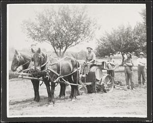 Four men and two horses with an agricultural machine