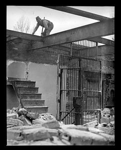 A man on the girders above the remains of a building