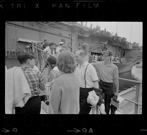Men, women, and children walking off USS Wasp
