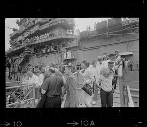 Men, women, and children walking off USS Wasp