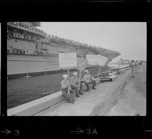 Sailors holding handmade signs