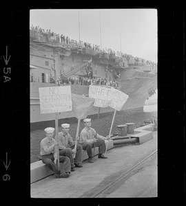 Sailors holding handmade signs