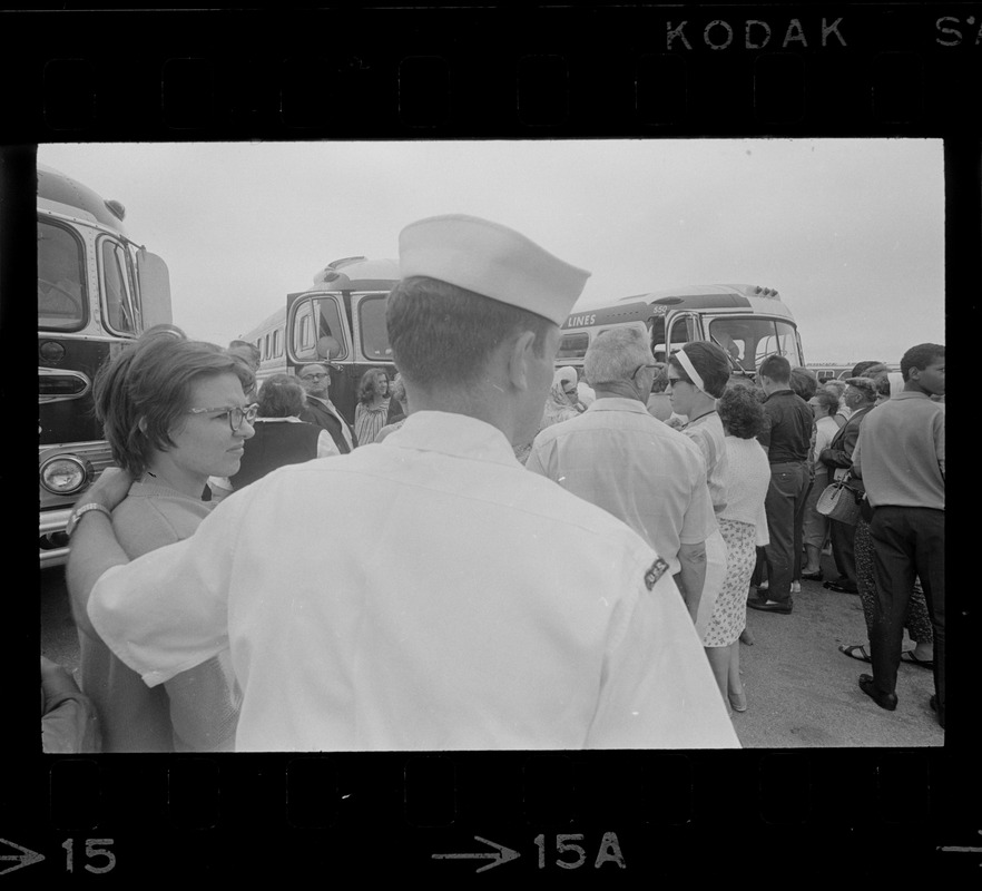 Group of civilians lining up to go onto buses