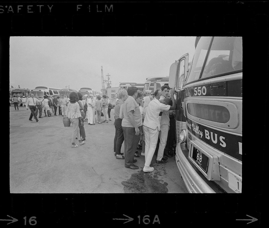 Group of civilians lining up to go onto buses