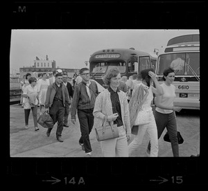 Group of civilians lining up to go onto buses