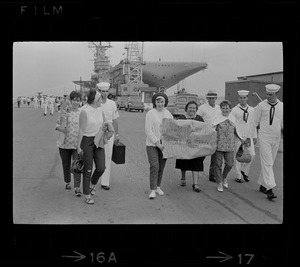 Group leaving the Aircraft Carrier Wasp uses this sign to express sentiments over being unexpected guests on the giant warship as it docked at the Naval Air Station in Quonset Point, RI