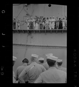 Sailors looking up at people on ship's deck