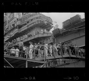 Men, women and sailors walking off ship