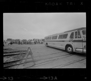 Group of civilians lining up to go onto buses