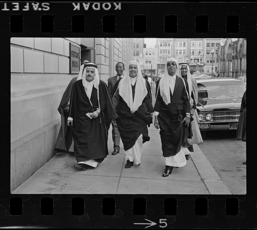 Group of men wearing bisht over thawb outside Sheraton Plaza Hotel