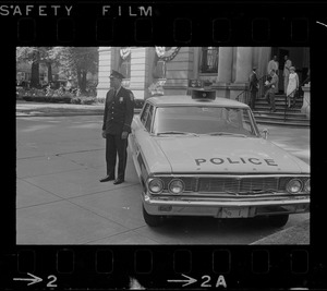 Officer standing next to police car