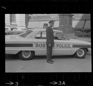 Officer standing next to police car