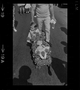 Young girl pushing a doll in a stroller decorated with ribbons during Bunker Hill Day Parade