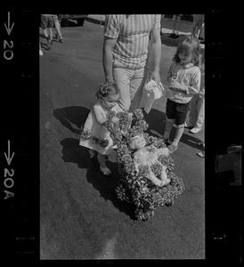 Young girl pushing a doll in a stroller decorated with ribbons during Bunker Hill Day Parade