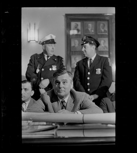 Edward J. Logue of the Boston Redevelopment Authority during hearing, with police officers right behind him
