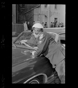 Police officer placing a ticket on car windshield during Boston Redevelopment Authority sit-in