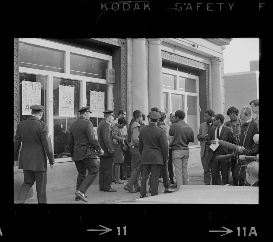 Crowd, including policemen and reporters, outside Boston Redevelopment Authority South End office