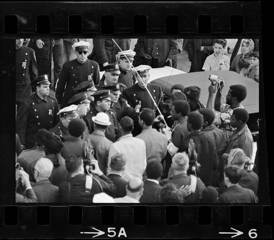 Police officers talking to a crowd of people outside Boston ...