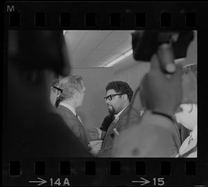 Mayor White speaking with a man with glasses in Boston Redevelopment Authority office during BRA sit-in