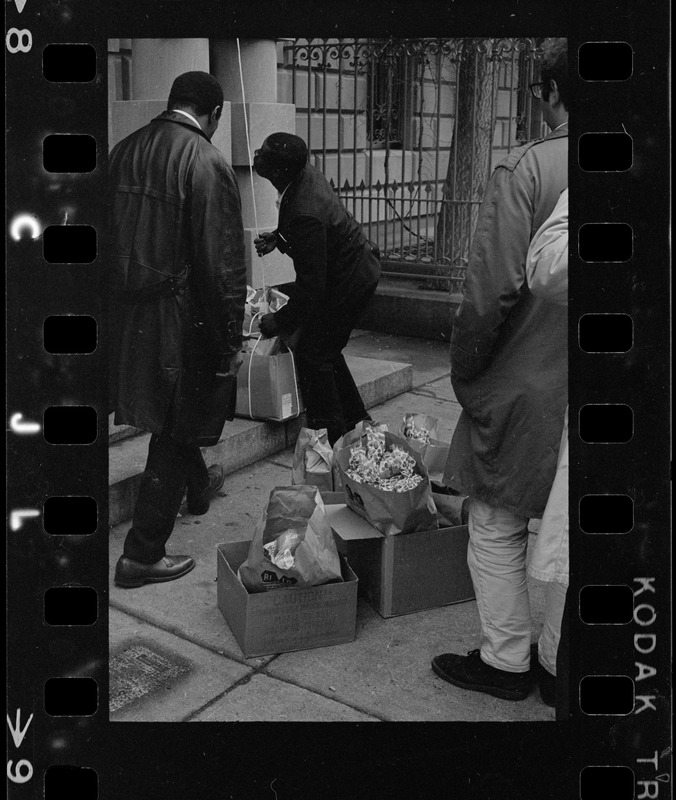 People hoisting supplies outside of building at Boston University during sit-in
