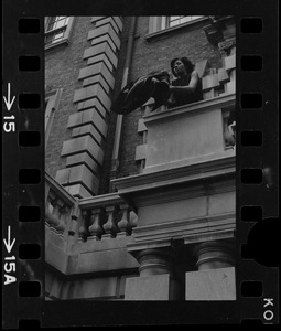 Student seen outside on balcony of Boston University administration building holding a jacket
