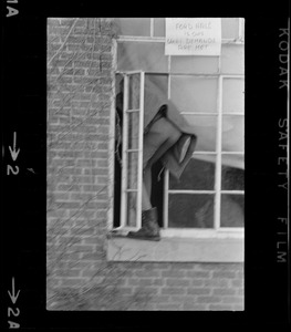 Student climbing into a window at Brandeis University with sign above it that reads "Ford Hall Is Ours Until Demands are Met"