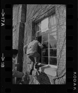 Student climbs into a window at Brandeis University with sign above it that reads "Ford Hall Is Ours Until Demands are Met"