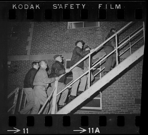 Group of men going up rear fire escape of Ford Hall