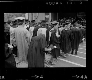 Group of Brandeis University graduates wear clenched fist, the symbol of student resistance, on the back off their robes during commencement