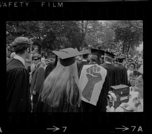 Brandeis University graduates with some wearing clenched fist, the symbol of student resistance, on the back off their robes during commencement