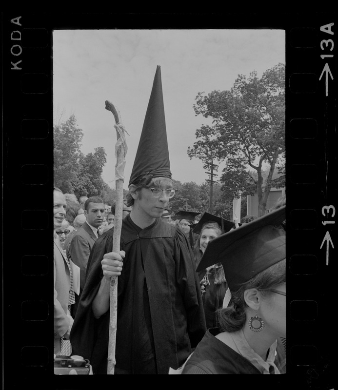 Student at Brandeis University commencement exercises wearing a dunce cap and carrying a stick