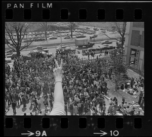 Hand in peace sign with crowds of people below during Students for a Democratic Society demonstration at Boston University