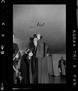 Former Supreme Court Chief Justice Earl Warren putting on graduation cap at Boston College commencement