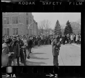 Cameraman seen in front of a crowd at Boston College sit-in