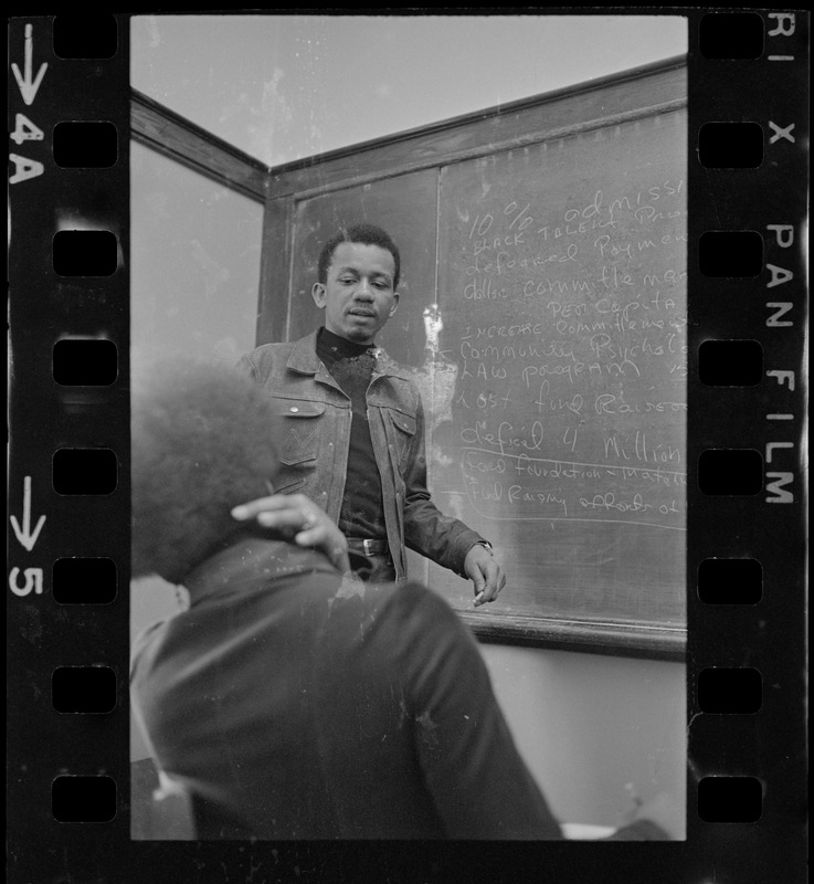 Student in front of blackboard at Boston College sit-in by 30 black students