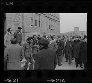 Crowd outside of Gasson Hall during Boston College sit-in while students exit building, one carrying a chain