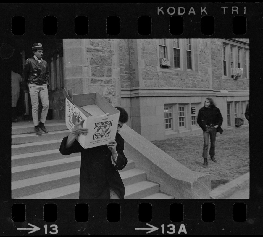 Student leaving Gasson Hall at Boston College during sit-in and carrying a box