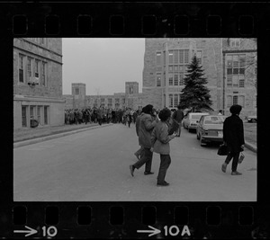 Students leaving Gasson Hall at Boston College during sit-in and crossing walkway with crowds in background